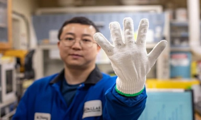 Một thành viên nhóm nghiên cứu đeo găng tay khâu sợi twistron. Ảnh: UT